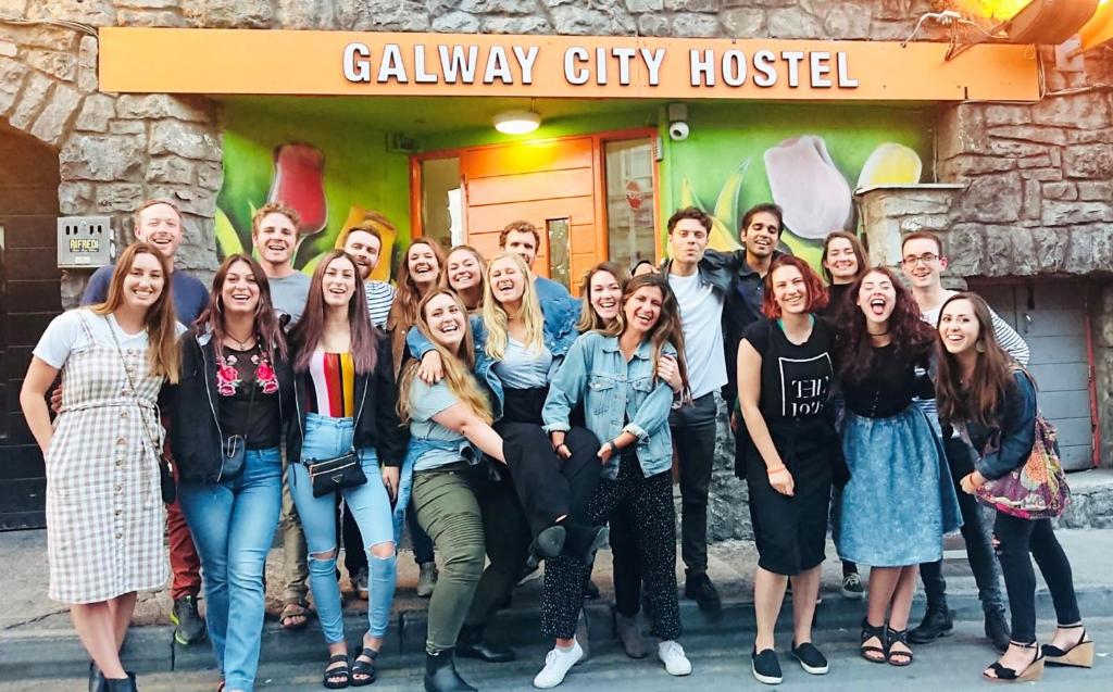 a group of people posing for a picture in front of a building at Galway City Hostel in Galway