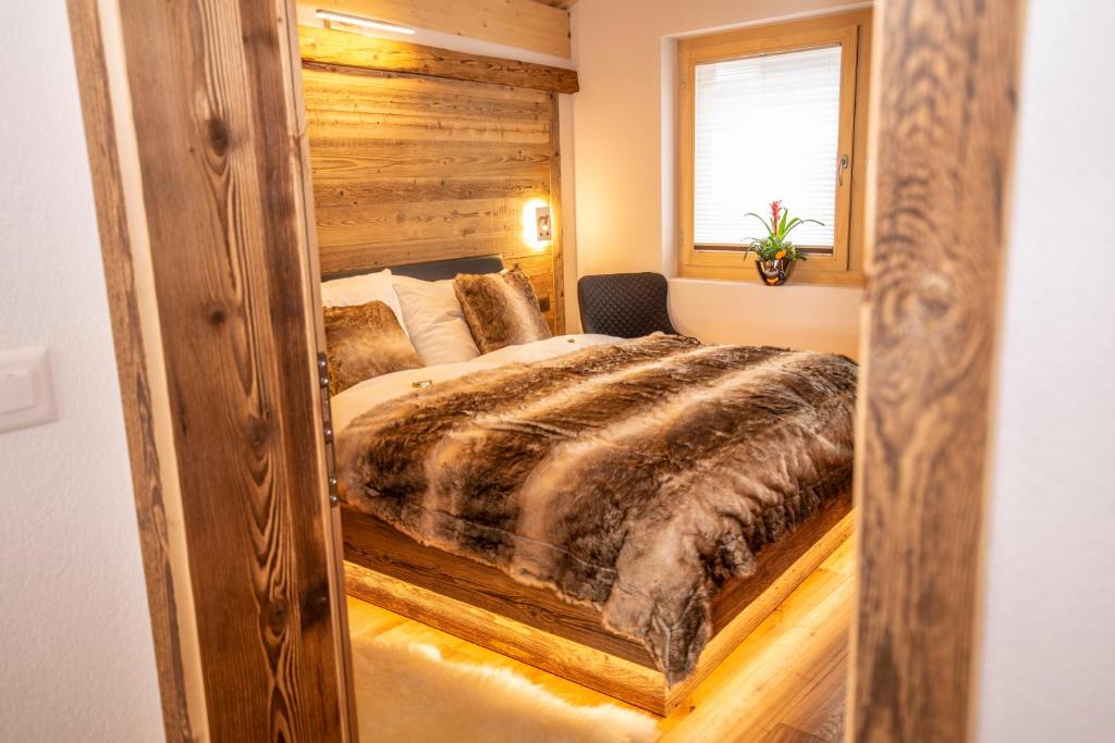 a bedroom with a bed with a large mirror at Palace Luxury Wellness Apartment and Boutique Hotel Ski-in-out in Saas-Fee