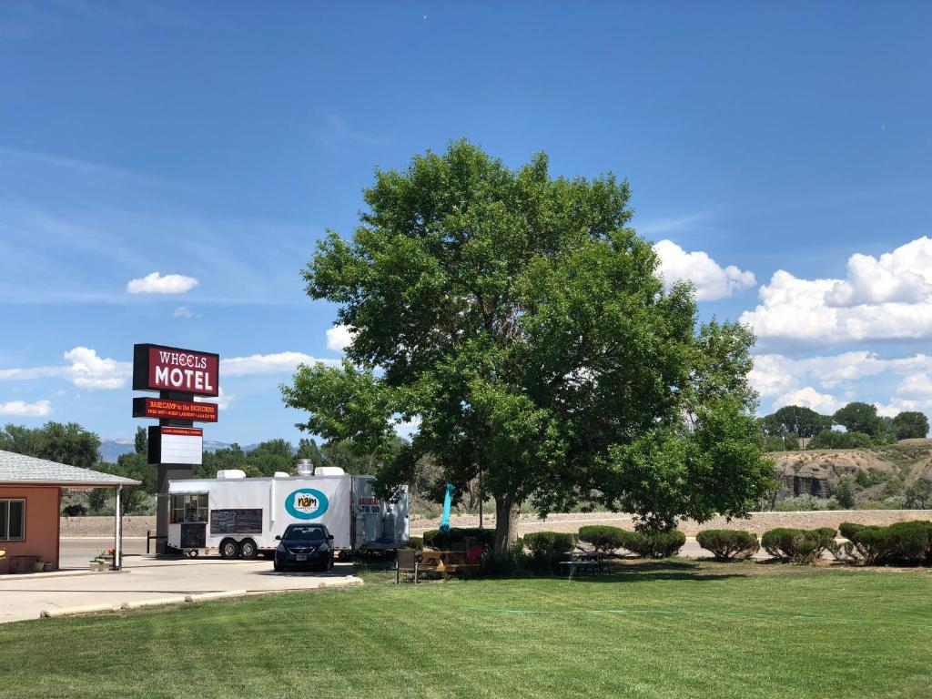 Greybull的住宿－Wheels Motel，停在汽车旅馆前的一辆卡车,车上有一棵树