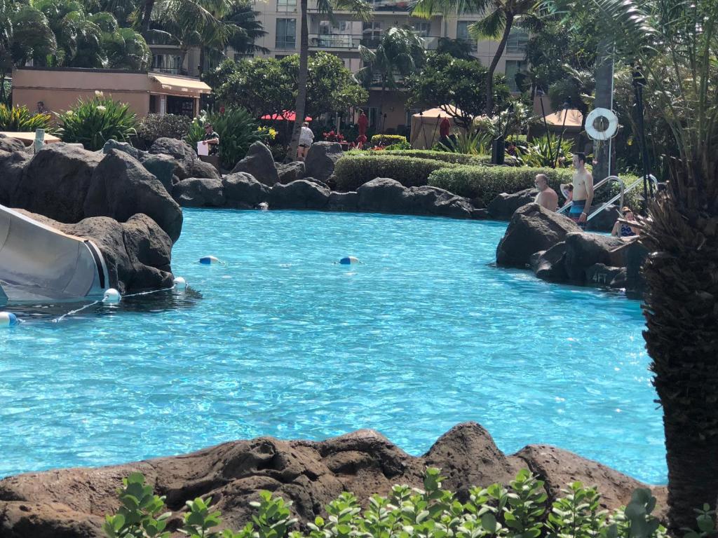 a pool in a resort with people in the water at Honua Kai - Hokulani 110 - 2 Bed 2 Bath Apartment in Honua Kai Resort in Lahaina