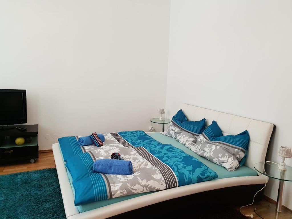 Cama blanca con sábanas y almohadas azules en Nina, en Viena