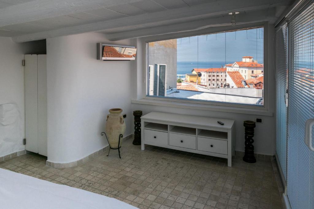 Schlafzimmer mit einem großen Fenster mit Stadtblick in der Unterkunft Apartment Sebastijan in Piran
