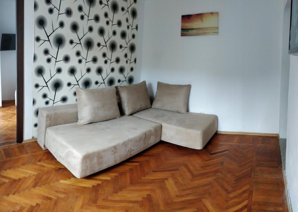 コンスタンツァにあるConstanta City Apartmentのウッドフロアのリビングルーム(白いソファ付)