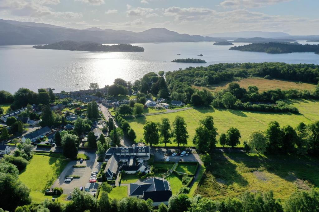 an aerial view of a house on a hill next to a lake at The Loch Lomond Arms Hotel in Luss