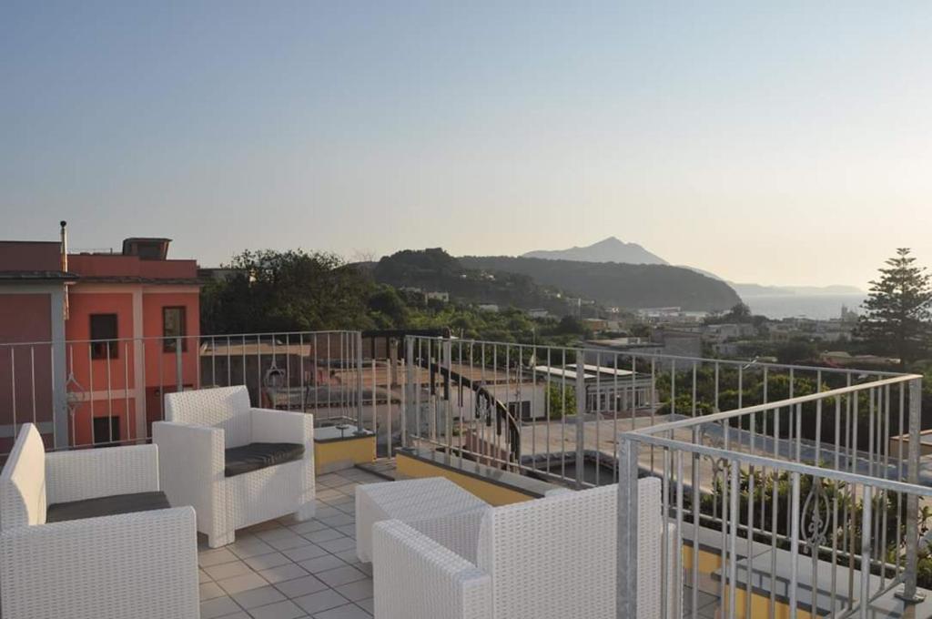 a balcony with white chairs and a view of a city at Dalla Maestra Lucia in Procida