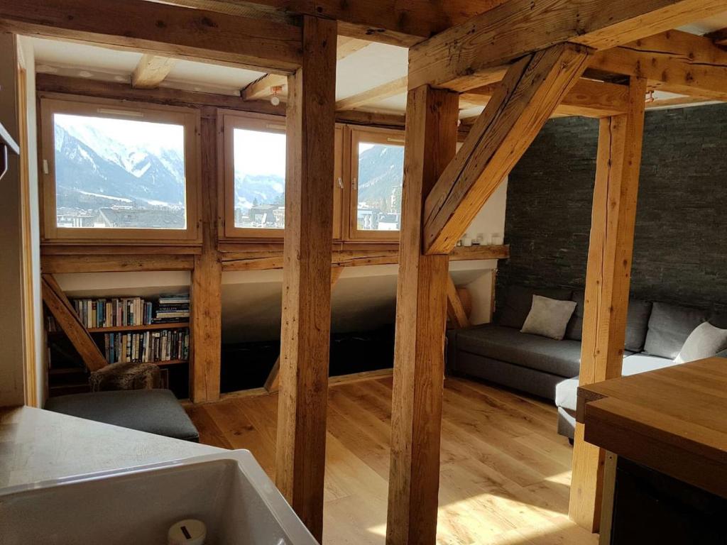 Beautiful apartment in Chamonix centre with superb mountain views في شامونيه مون بلان: غرفة معيشة مع نافذة كبيرة وأريكة