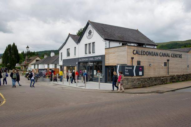 un groupe de personnes marchant devant un bâtiment dans l'établissement Lock Chambers, Caledonian Canal Centre, à Fort Augustus