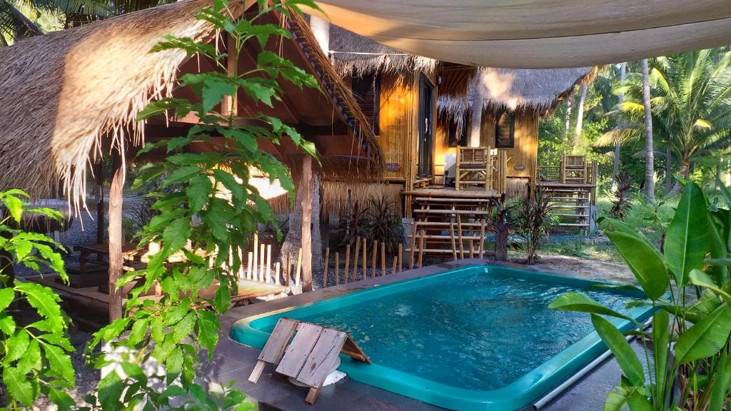 een huis met een zwembad in een tuin bij Seacroft Bamboo Village in Hinkong