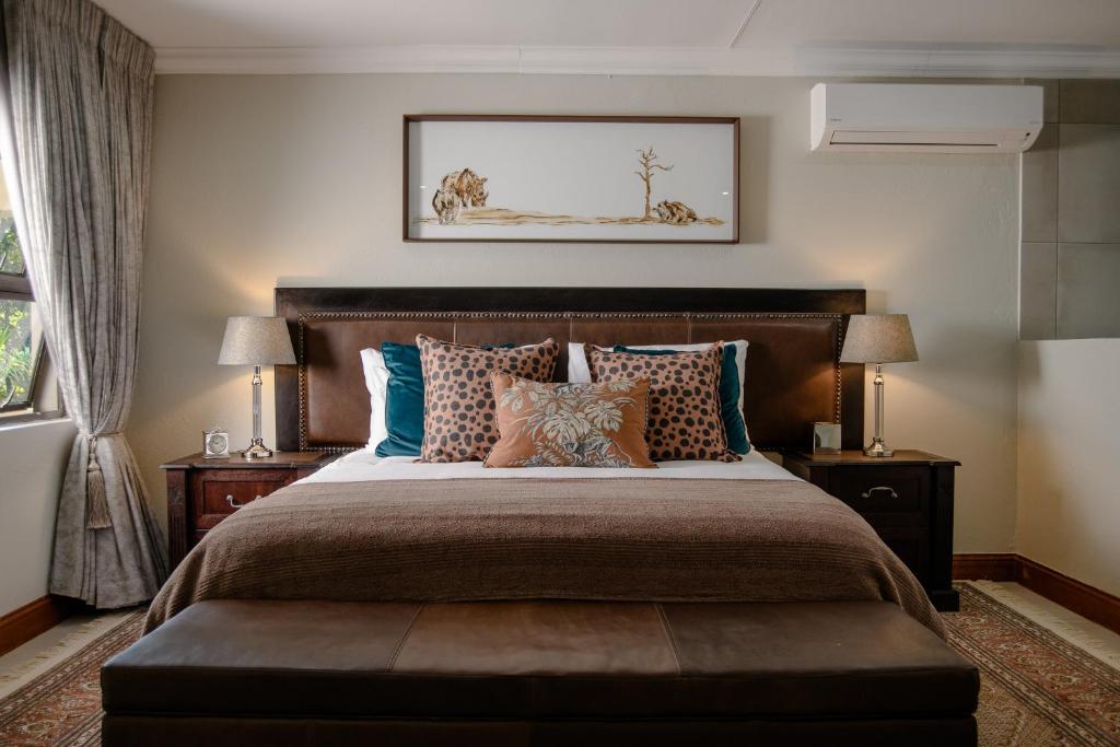 um quarto com uma cama grande e almofadas em The Reserve Boutique Hotel em Hazyview