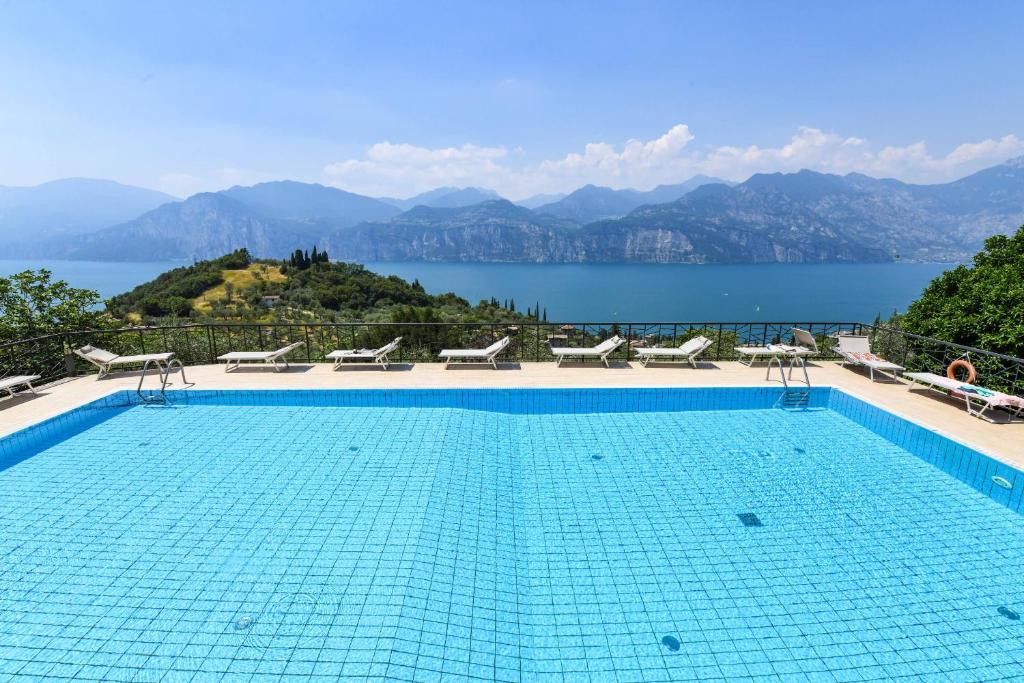una piscina con vista sull'acqua e sulle montagne di Garden Residence Malcesine Lake View a Malcesine