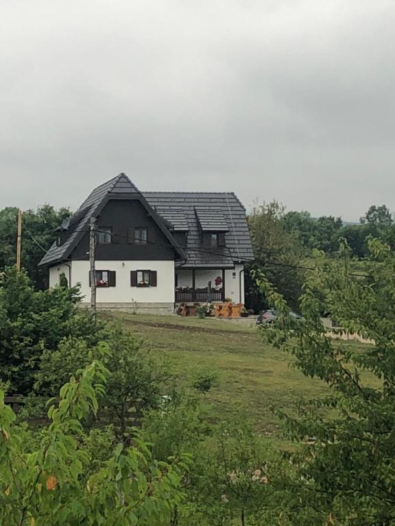 een zwart-wit huis in een veld bij House Flora in Rastovača