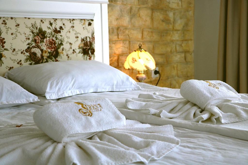 a white bed with towels on top of it at Sirena Palace Family Hotel in Obzor
