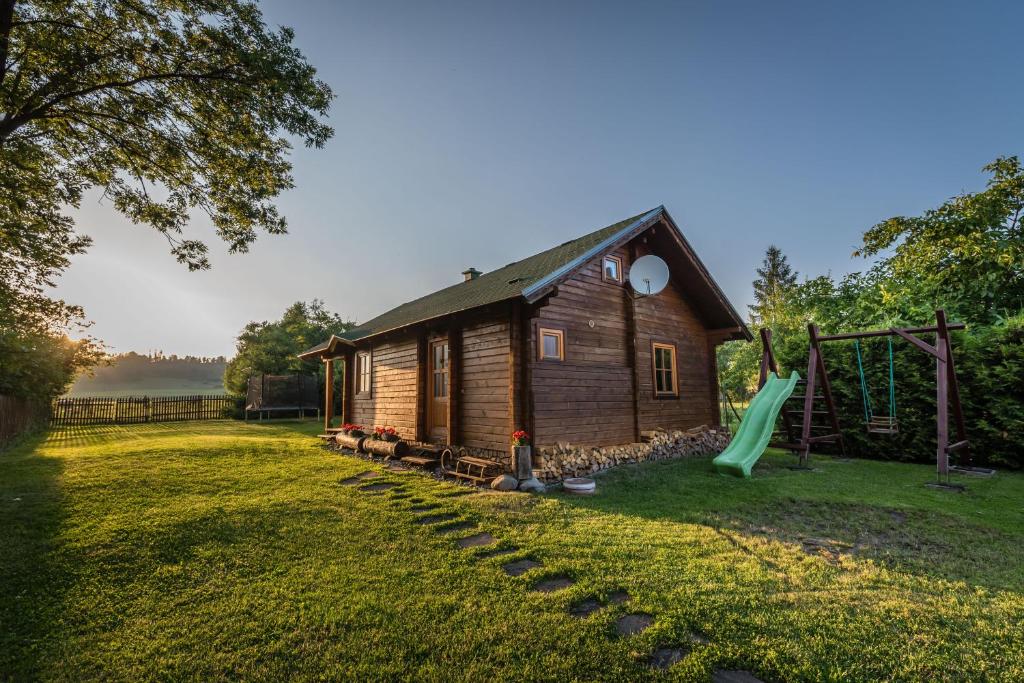 a log cabin with a slide and a playground at Montana Bobrovec in Bobrovec