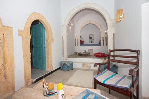 a living room with two arched doors and a table at Dar Tenast in Houmt Souk