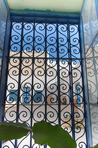 a metal grate with a window on a wall at Dar Tenast in Houmt Souk