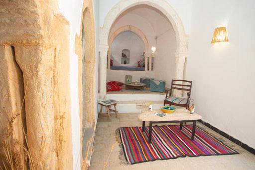 a living room with a table and a couch at Dar Tenast in Houmt Souk