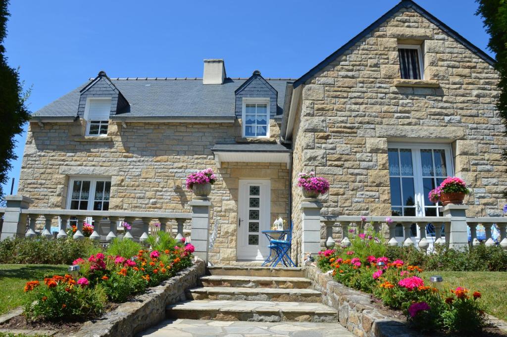 uma casa de pedra com flores em frente em Chez Brigitte chambres à l habitant em Le Minihic-sur-Rance