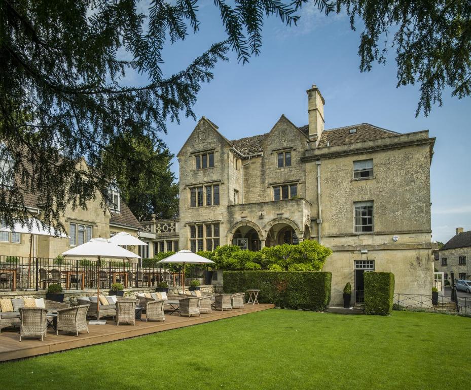 an exterior view of a building with chairs and umbrellas at The Painswick in Painswick