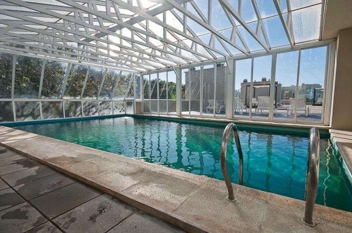 a swimming pool in a building with a large window at Terrazas de Carilo in Carilo