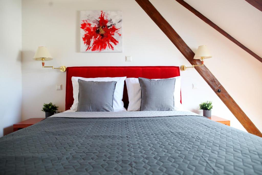 a bedroom with a large bed with a red headboard at Sobe Bimbo in Zaprešić