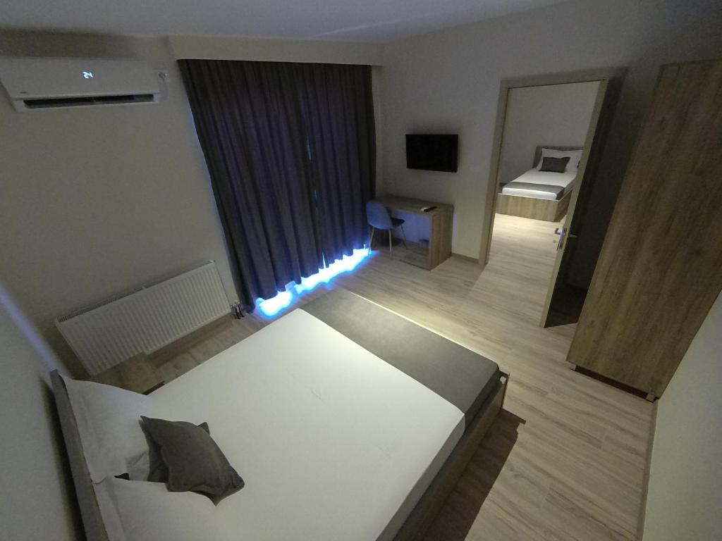um quarto de hotel com uma cama e um espelho em Hotel Vila Nino em Berat
