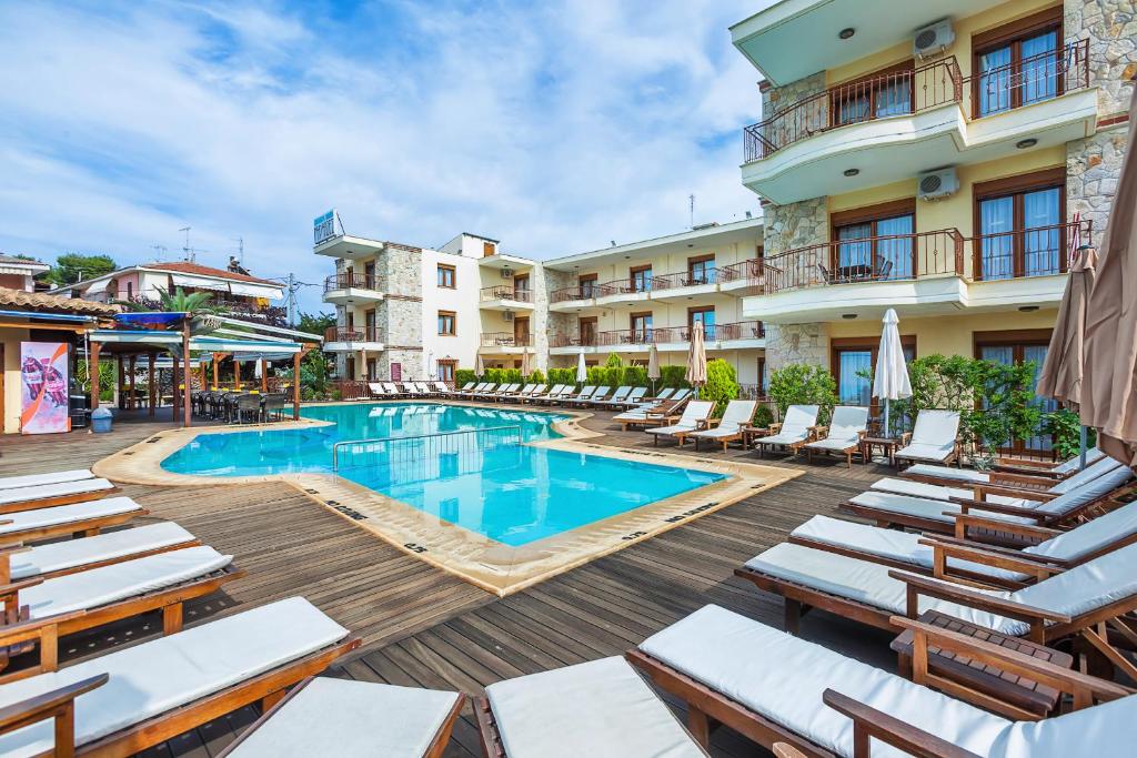 a hotel with a swimming pool and lounge chairs at Nereides Hotel in Hanioti