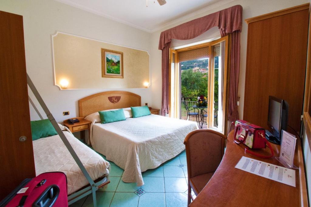 pokój hotelowy z łóżkiem i telewizorem w obiekcie Hotel Savoia Sorrento w Sorrento