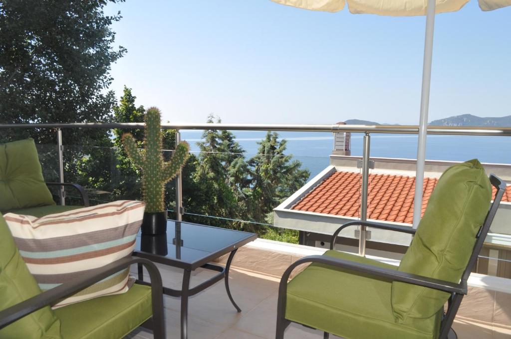 einen Balkon mit Stühlen, einem Tisch und Meerblick in der Unterkunft Markellas Summer House in Palaió Tsiflíki