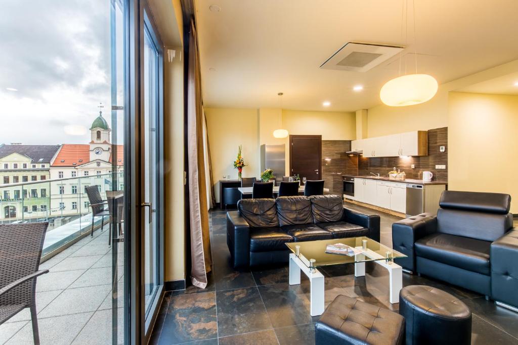 a living room with couches and a view of a kitchen at Rezidence Fontána in Teplice