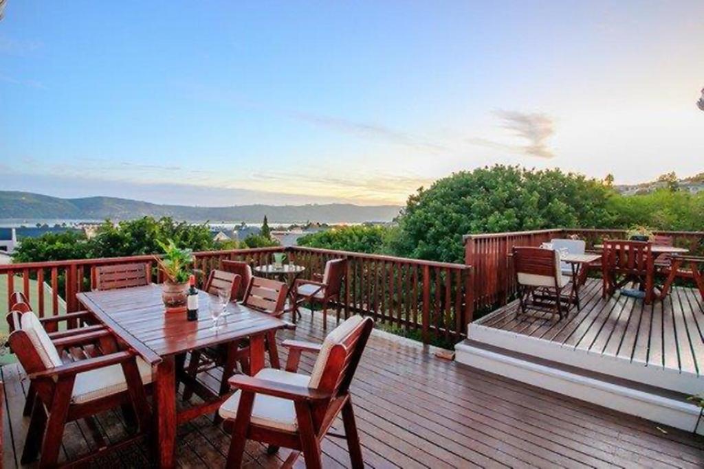 a wooden deck with tables and chairs on it at Knysna Manor House in Knysna