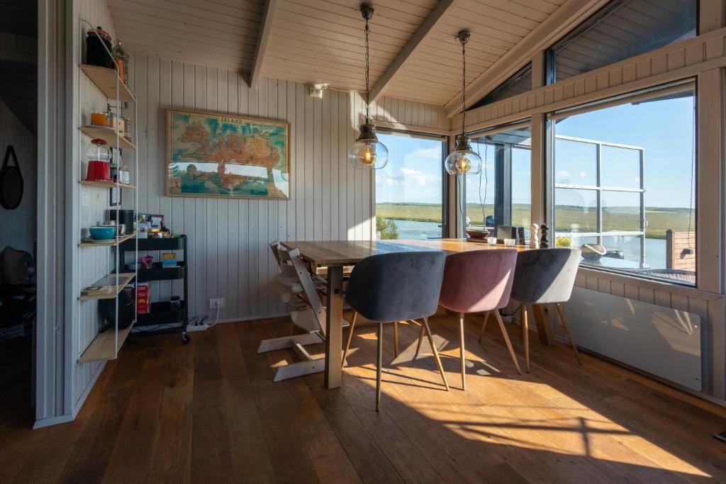 comedor con mesa y algunas sillas en GreenKey Paradise Cabin, en Selfoss