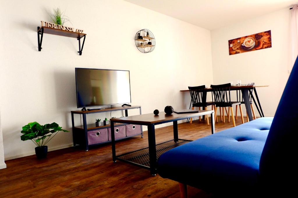 a living room with a tv and a table at Sweet Park Appartements in Rheinhausen