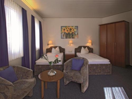 ブラウンシュヴァイクにあるHotel Köhlerのベッド、ソファ、椅子が備わるホテルルームです。