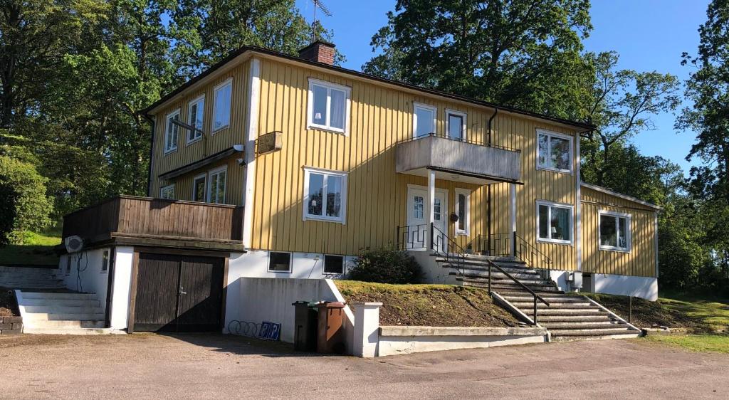 a yellow house with a garage in front of it at Bergåsa bed & kitchen Drängsered in Torup