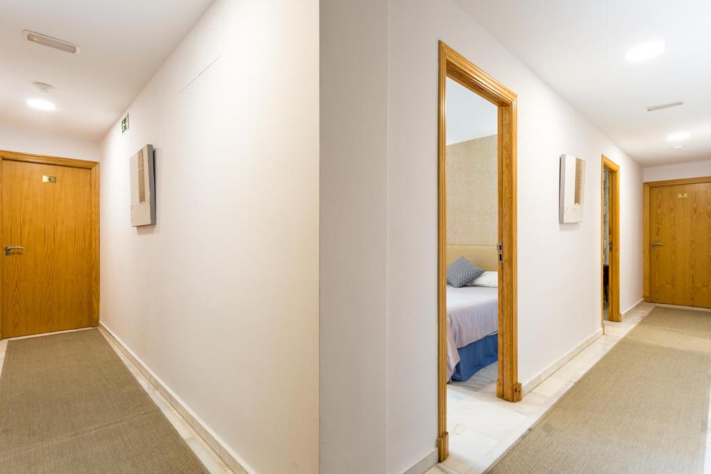 a hallway with a mirror and a bed in a room at Hotel Nómadas in Vejer de la Frontera
