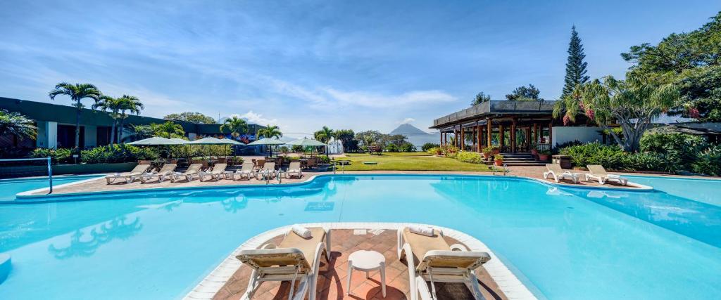 a large swimming pool with chairs and a resort at Porta Hotel del Lago in Panajachel