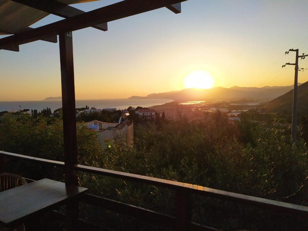 a person standing on a hill with the sunset in the background at Hotel Belvedere in Sperlonga