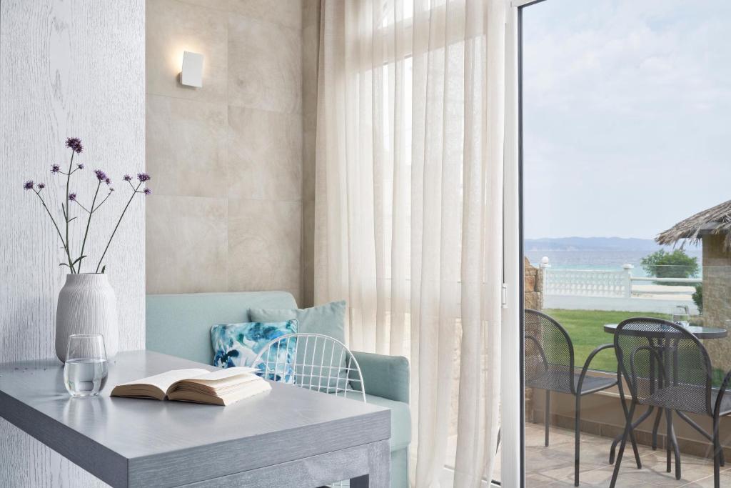 a table with a book on it next to a balcony at Antigoni Seaside Resort in Ormos Panagias