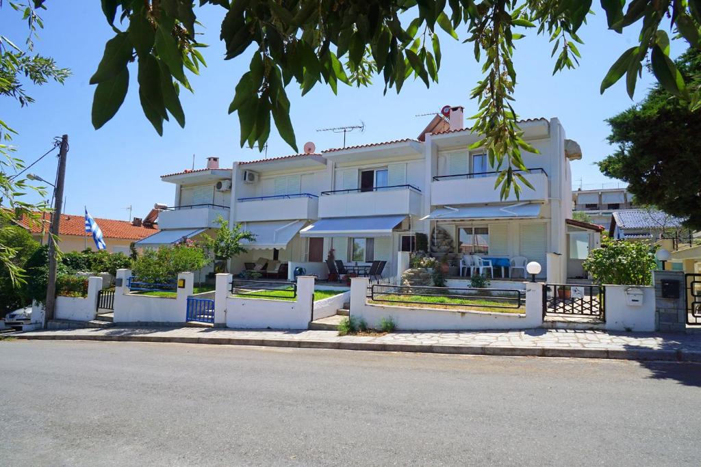 uma casa branca com uma cerca à frente. em Aegean Blue in Palio Kavala em Kavala