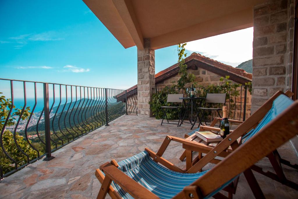 a patio with chairs and a table and the ocean at Villa Ladera Lapcici in Budva