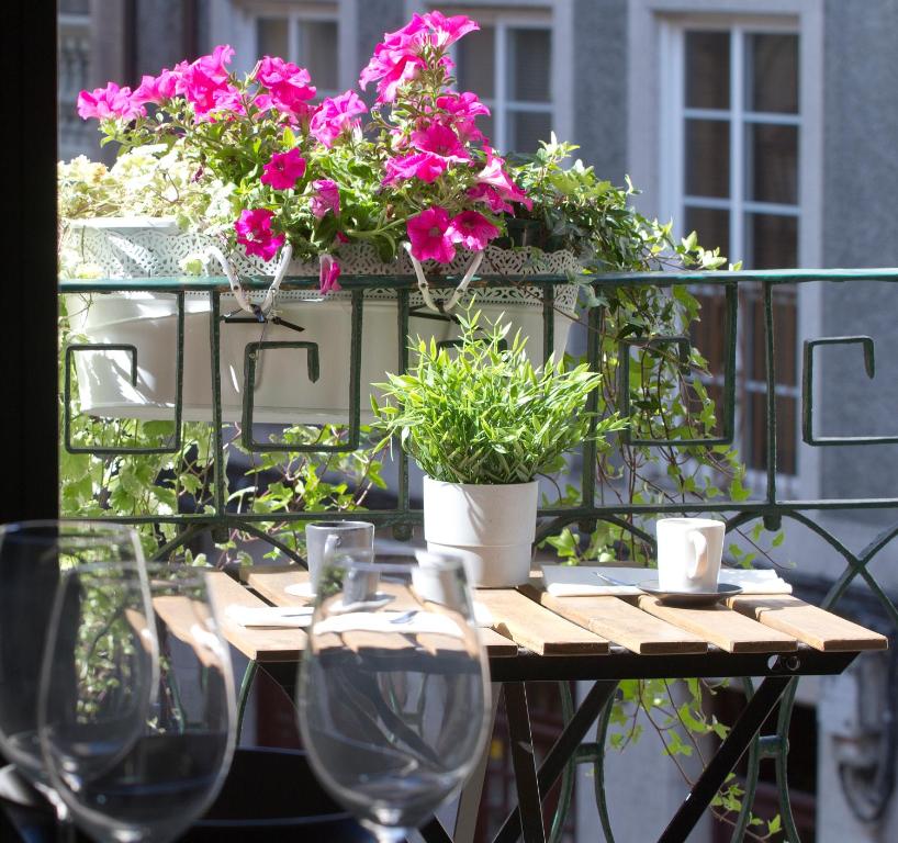 a table with wine glasses and flowers on a balcony at Acio blanco. Loft en el Casco Histórico de Ourense in Ourense