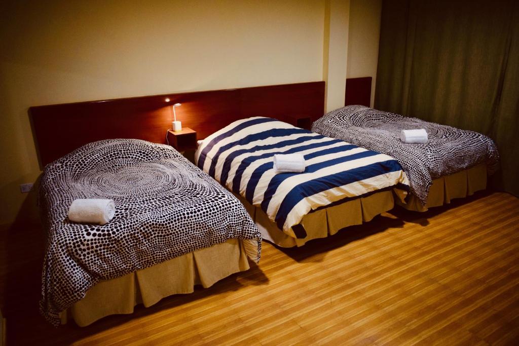 2 camas en una habitación de hotel con lámpara en Almudena Suites Uyuni en Uyuni