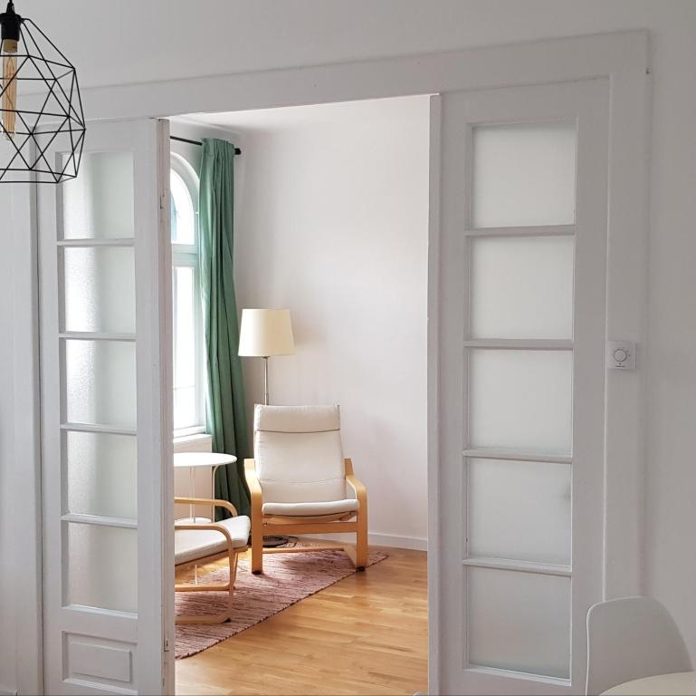 a living room with a chair and a table at Old Town Apartament in Târgovişte