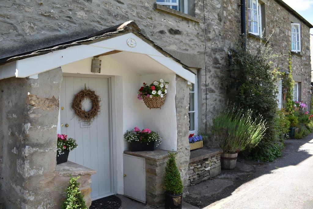 um edifício com uma garagem branca com flores em No 2 em Kirkby Lonsdale