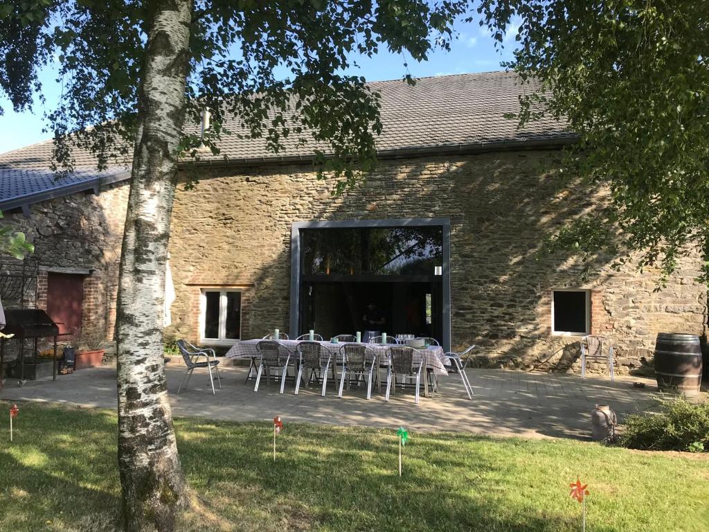 a table and chairs in front of a building at Ferme du Grand Frêne in Naomé