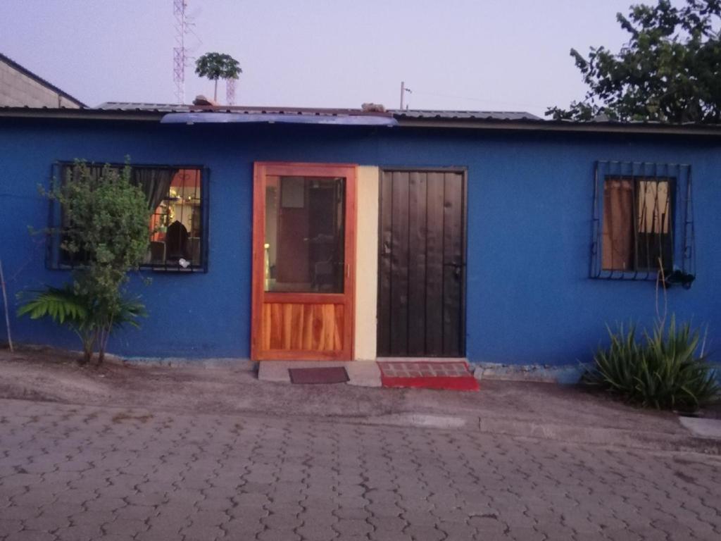 una casa blu con una porta in legno e una finestra di Hospedaje Arvakeni a San Cristóbal