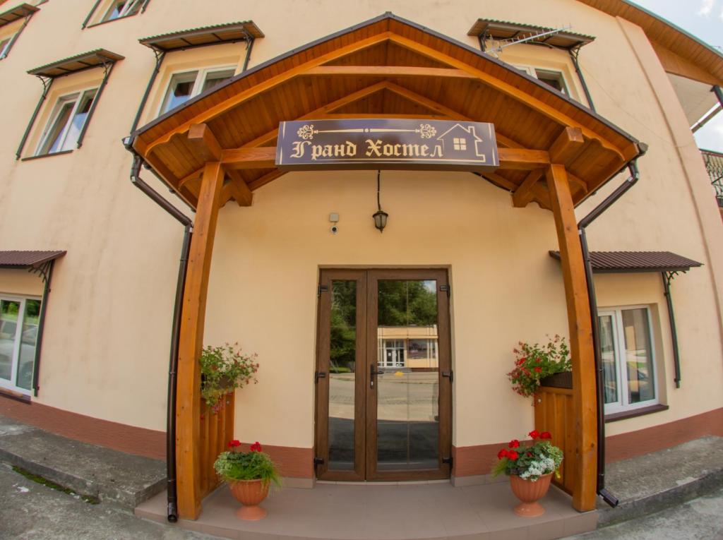 un bâtiment avec un panneau devant lui dans l'établissement Гранд Хостел, à Tchernivtsi