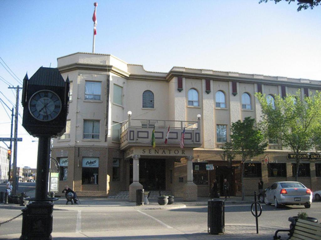 un gran edificio con un reloj delante en Hotel Senator, en Saskatoon