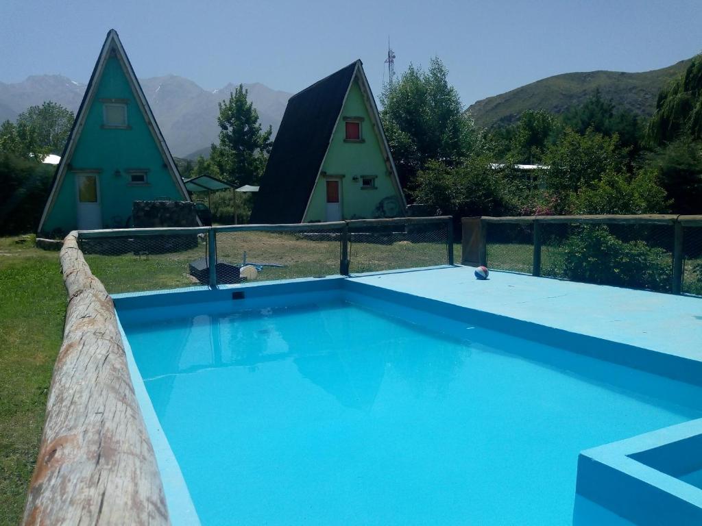 a swimming pool with a couple of yurt houses at Complejo de Cabañas Tierra de Luna in Potrerillos
