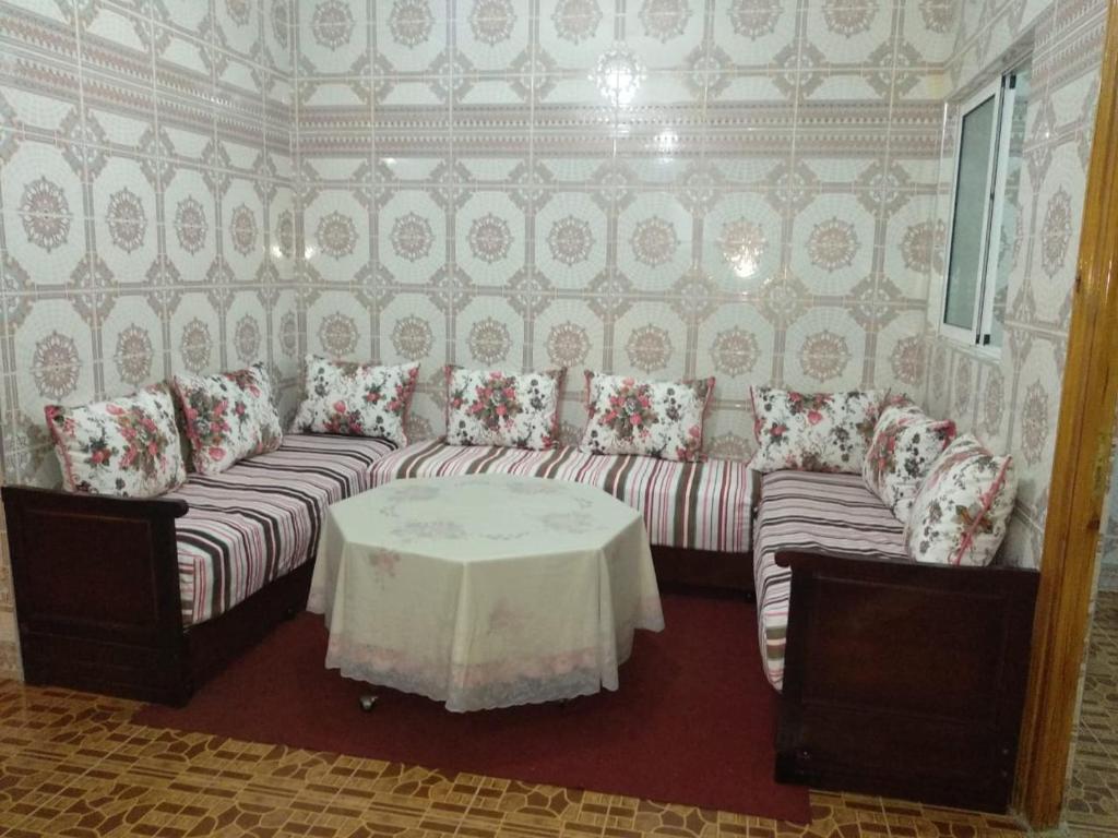 salon z kanapą i stołem w obiekcie Appartement belle vue w mieście Mʼdik